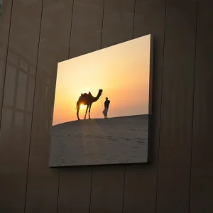 Canvastavla med LED-belysning 28x28 cm - Kamel och människa i solnedgång på sanddyner Orange / Gul / Svart - Inredning Köp nu