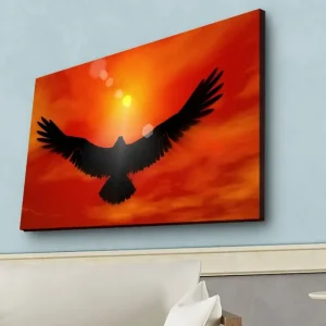 Canvastavla med LED-belysning - Silhuett av en örn som flyger mot en solnedgång i starka färger Röd / Svart / Orange - Inredning Utförsäljning